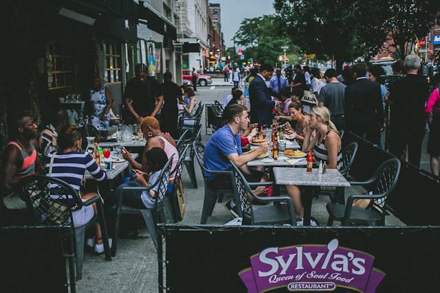 Diners enjoying soul food in the summer at Sylvia's